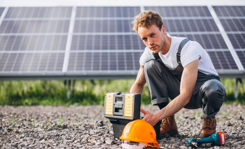 Technik čistí solárne panely počas jesennej údržby fotovoltiky pred zimou