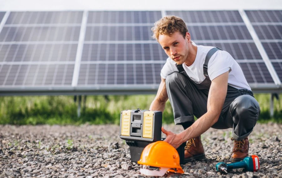 Technik čistí solárne panely počas jesennej údržby fotovoltiky pred zimou